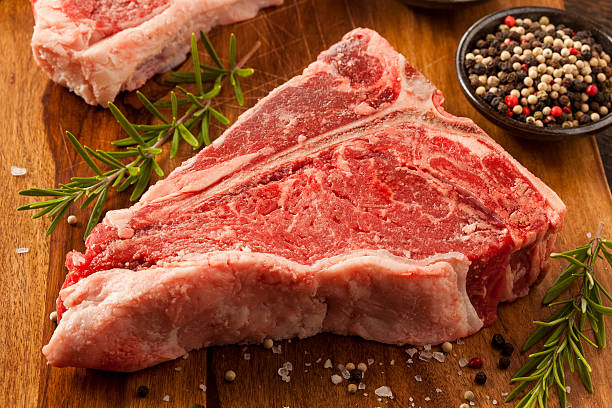 Thick Raw T-Bone Steak with Seasoning and Rosemary